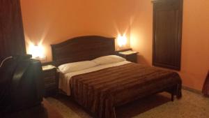 ローマにあるピタゴーラ B＆Bのベッドルーム1室(ベッド1台、ナイトスタンド2台、ランプ2つ付)