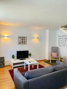 a living room with a couch and a tv at Urban Lodge in Braga
