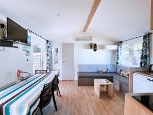 a small living room with a couch and a table at Le Ti Buch Mobilhome en Camping 4 étoiles avec Terrasse Plancha et Climatisation in La Teste-de-Buch
