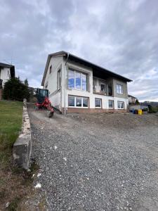 a house with a tractor parked in front of it at Ferienwohnung Schlossblick in Bad Laasphe
