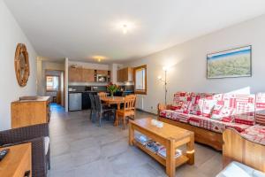 ein Wohnzimmer mit Sofa und Tisch in der Unterkunft Appt Cosy centre ville à 5 min des stations de ski in Saint-Jean-de-Sixt