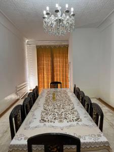 a room with a long table with chairs and a chandelier at Kulolchi hotel khiva in Khiva