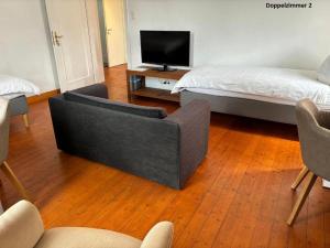 a living room with a bed and a couch and a tv at Apartments Jembke, küchen,check in on line , Gratis P ,Wi-Fi! in Jembke
