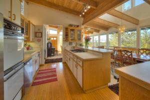a large kitchen with white appliances and a dining room at Enviable Lake & Mountain Views Wth Waterfall in South Lake Tahoe +13 photos