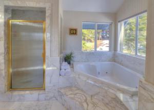 a large bathroom with a tub and a window at Enviable Lake & Mountain Views Wth Waterfall in South Lake Tahoe