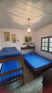 - 2 lits dans une chambre avec des draps bleus dans l'établissement Casa de Campo em Juiz de Fora Granja 6 de Maio, à Chácara