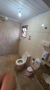 une salle de bain avec toilettes, lavabo et fenêtre dans l'établissement Casa de Campo em Juiz de Fora Granja 6 de Maio, à Chácara
