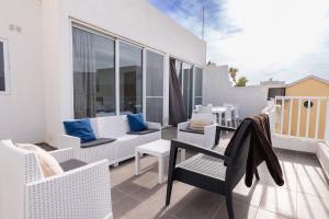 a balcony with white furniture and blue pillows at Luigi penthouse in St. Paul's Bay