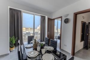 a dining room with a table and a large window at Luigi penthouse in St. Paul's Bay