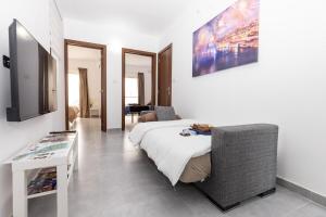 a bedroom with a bed and a tv and a table at Luigi penthouse in St. Paul's Bay