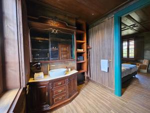 a bathroom with a sink and a bed in a room at Ecoresort Portobali in Jugueiros