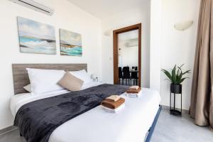 a bedroom with a bed with two towels on it at Luigi penthouse in St. Paul's Bay
