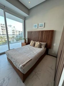 a bedroom with a large bed and a large window at Departamento Arrecife Beach, Nuevo Vallarta in Nuevo Vallarta 