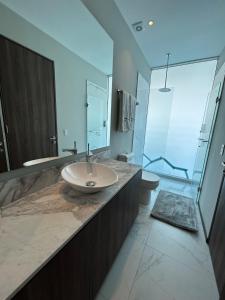 a bathroom with a sink and a glass shower at Departamento Arrecife Beach, Nuevo Vallarta in Nuevo Vallarta 