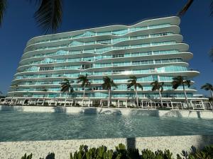 a large building with palm trees in front of it at Departamento Arrecife Beach, Nuevo Vallarta in Nuevo Vallarta 