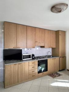 a kitchen with wooden cabinets and a microwave at Trilo La Rindela in Folgaria +6 photos
