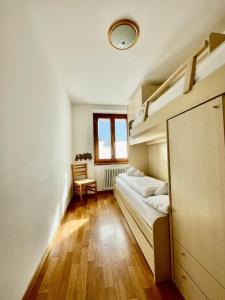 a bedroom with two bunk beds and a window at Trilo La Rindela in Folgaria