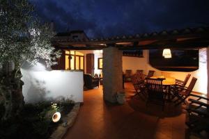 a patio with a table and chairs at night at VILLA GILDA CON DEPANDACE PISCINA e GIARDINO in La Ciaccia