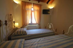 a bedroom with two twin beds and a window at VILLA GILDA CON DEPANDACE PISCINA e GIARDINO in La Ciaccia +17 photos