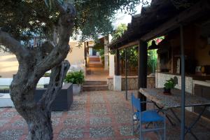 a patio with a table and chairs and a tree at NIDU - Dimora del benessere in Trappeto