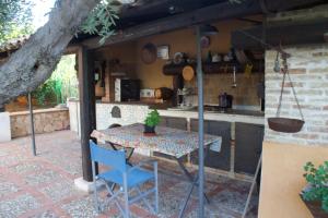 a table and chairs on a patio with a kitchen at NIDU - Dimora del benessere in Trappeto