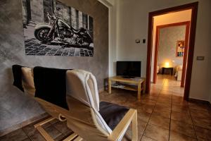 a living room with a chair and a motorcycle on the wall at Appartamenti La Chiocciola Como - Lipomo in Como