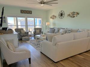 a living room with a white couch and chairs at Key Rest in Oak Island