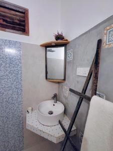 a bathroom with a sink and a mirror on the wall at Garnet Yala Beach in Kirinda