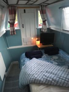 a small bedroom with a bed and a computer monitor at The Sitting Duck in Greet