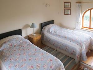 Un dormitorio con dos camas y una ventana. en The Stables, en Filby 5 fotos más