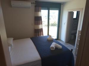 une chambre avec un lit avec deux animaux en peluche dessus dans l'établissement Manolis Stone House, à Kalithies