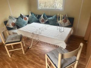 a living room with a table and a couch with pillows at Mobile home in Saint-Gérons