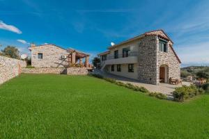 une grande cour en face d'une maison en pierre dans l'établissement Manolis Stone House, à Kalithies