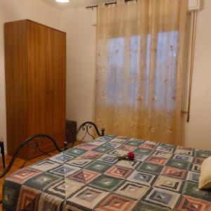 a bedroom with a bed with a quilt on it at Camera "La Margherita" in Pistoia