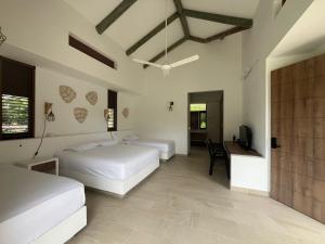 アナポイマにあるRoomy 4BR Villa with Pool at Mesa de Yeguasのベッド2台、机、テレビのある寝室
