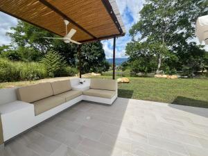 アナポイマにあるRoomy 4BR Villa with Pool at Mesa de Yeguasのパティオ(ソファ、天井ファン付)