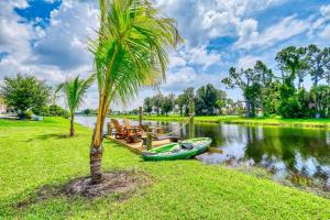a palm tree and a boat on the water at Waterfront Family Vacation , Near Ocean and Mineral Springs, 7 sleeps in Rotonda West