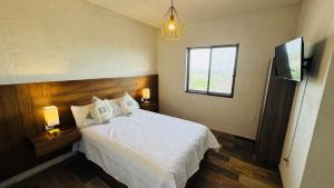 a bedroom with a white bed and a window at Peace of mind at Casa Brisa in Bernal