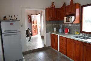 a kitchen with wooden cabinets and a white refrigerator at Miskysisa in Humahuaca