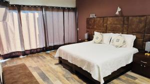a bedroom with a large bed with white sheets and pillows at Peace of mind at Casa Brisa in Bernal