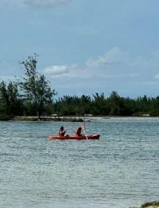 two people in a red canoe on a lake at Golden Lake Residence Apart Hotel in Arraial do Cabo