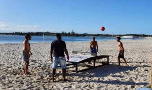 a group of men playing a game of volley ball on the beach at Golden Lake Residence Apart Hotel in Arraial do Cabo