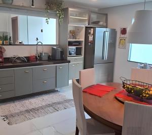 une cuisine avec une table en bois et un réfrigérateur dans l'établissement Casa em São Pedro da Aldeia - RJ, à São Pedro da Aldeia