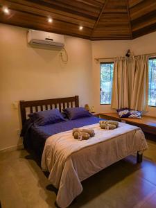 ein Schlafzimmer mit einem großen Bett mit zwei Schuhen darauf in der Unterkunft Casa de Miguel in Alto Paraíso de Goiás