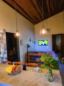 ein Wohnzimmer mit einem Tisch und einer Obstschale in der Unterkunft Casa de Miguel in Alto Paraíso de Goiás