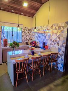 eine Küche mit Tisch und Stühlen und einer Theke in der Unterkunft Casa de Miguel in Alto Paraíso de Goiás