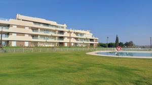 a large apartment building with a pool in front of it at Los Colibríes, Beach & Golf - By AC REAL in Isla Canela
