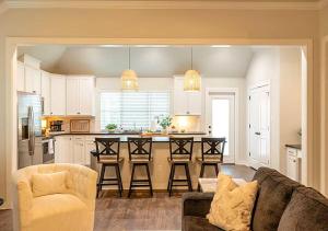 a living room with a couch and a kitchen at Luxury Home Near Kyle Field & Expo Center in Bryan