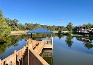 a wooden dock with a gazebo on a river at Luxury Home Near Kyle Field & Expo Center in Bryan