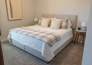 a bedroom with a bed with a plaid blanket and pillows at Luxury Home Near Kyle Field & Expo Center in Bryan +54 photos
